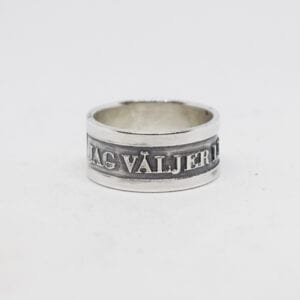 Ring med text och svartoxiderad bakgrund på vit botten