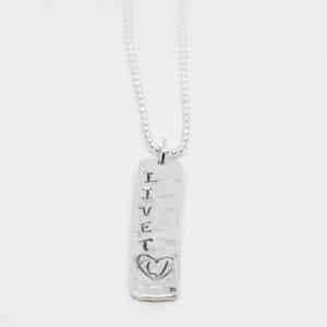silverhalsband med texten LIVET på vit botten
