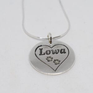 silverhalsband med hjärta och hundtassar på vit bakgrund
