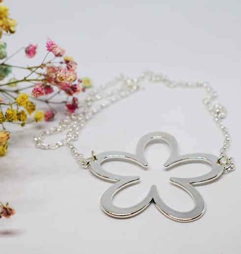 altiflower4-3.jpg silverhalsband i form av en stor blomma på vit bakgrund med små blommor i rosa och gult