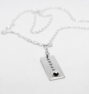 silverhalsband med texten ANDAS mot vit bakgrund