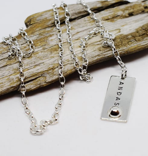 andasarmband7-2.jpg silverhalsband över träbit mot vit bakgrund