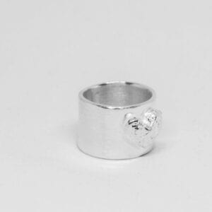 bred silverring med hjärta på vit botten