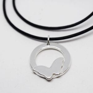 silversmycke med fjäril i läderrem på vit bakgrund