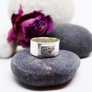 silverring med fågel på sten med lila ros bakom