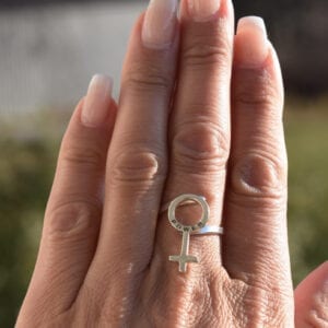 hand med silverring md kvinnosymbol utomhus