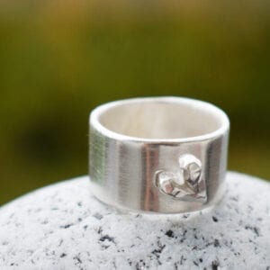 silverring med hjärta på sten utomhus