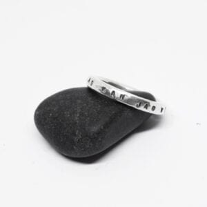 silverring med text på sten med vit bakgrund