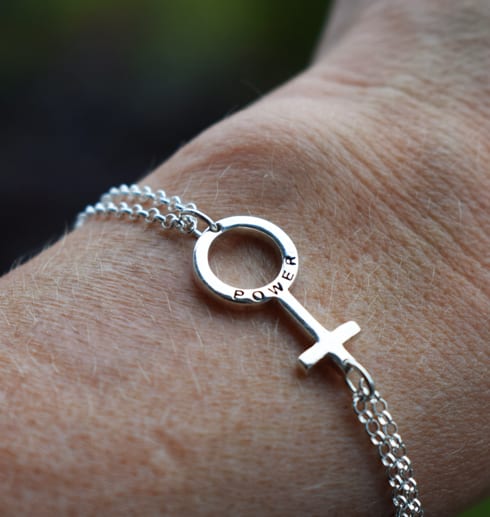 litetgirlpwerarmband kvinnosymbolen som armband på en arm- girlpower