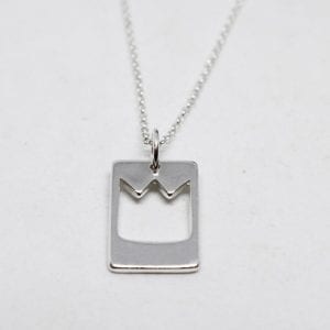 silverhalsband med utsågad prinskrona mot vit bakgrund