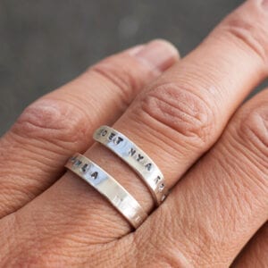silverring med text på finger utomhus