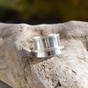 bred silverring på träbit utomhus