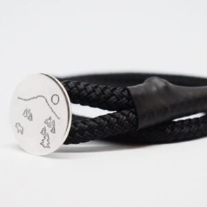 armband med svart rem och silverplatta på vit botten