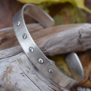 silverarmband med stenar på trädgren utomhus