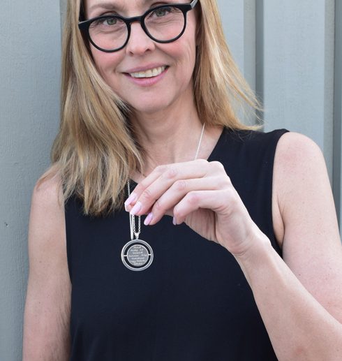 words2 Runt silverhalsband i lång kedja på kvinna i svart klänning utomhus