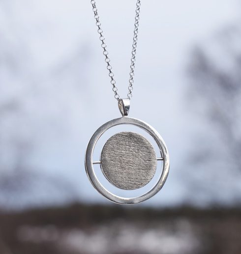 words7 silverhalsband i rund form med matterad yta hängande i luften