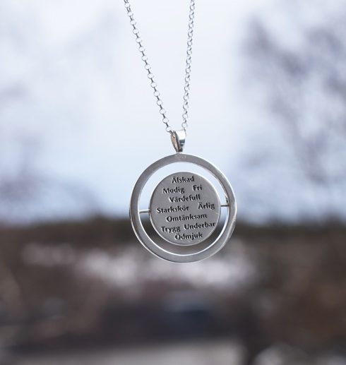 words8 Silverhalsband med rund form med 10st ord hängande i luften utomhus