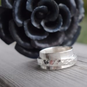 silverring med svart smidesros bakomutomhus